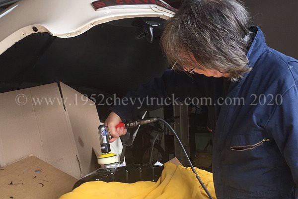 Polishing the car with an air polishing tool.